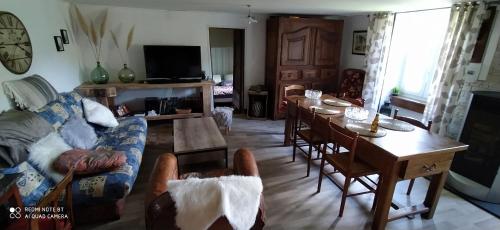 un salon avec un canapé et une table dans l'établissement Gite grand champ, à Villeneuve-dʼAllier
