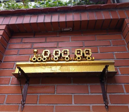 a gold clock on the side of a brick building at Noclegi "Poza Szlakiem" in Wałbrzych