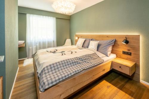 a bedroom with a large bed with a wooden headboard at Haus Cervino - luxury apartment in Zermatt