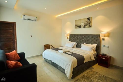 a hotel room with a bed and a couch at AIDEN HOMES AND APARTMENTS HOTEl in Koforidua