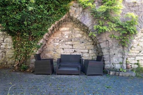 Un grupo de sillas contra una pared de piedra. en Large 4 bedroom Villa with beautiful garden, en Visby