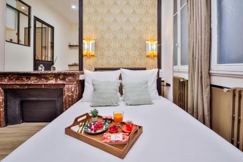 - une chambre d'hôtel avec un lit et un plateau de nourriture dans l'établissement WS Opéra - Edimbourg, à Paris