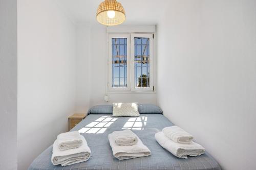 a bedroom with a bed with towels on it at La Terracita de Candi El Puerto in El Puerto de Santa María
