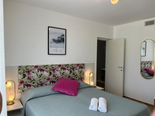 a bedroom with a blue bed with two white slippers at NEW Villa Tosca in Bardolino