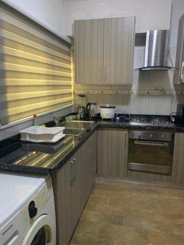 a kitchen with a sink and a washer and dryer at Beige Villa at East Legon ANC in Accra