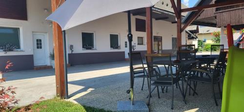 a table and chairs under an umbrella on a patio at Rooms & Apartments Kepic, AIRPORT accomodation in Cerklje na Gorenjskem