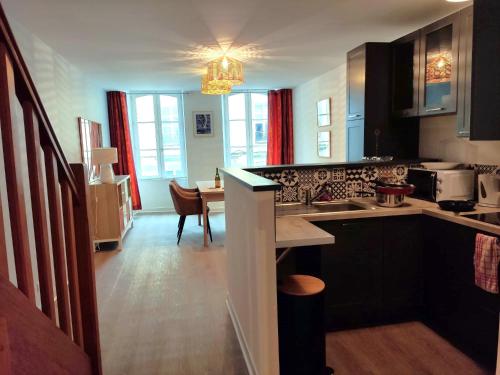une cuisine avec un évier et une table à l'intérieur dans l'établissement Duplex en centre-ville, à Morlaix