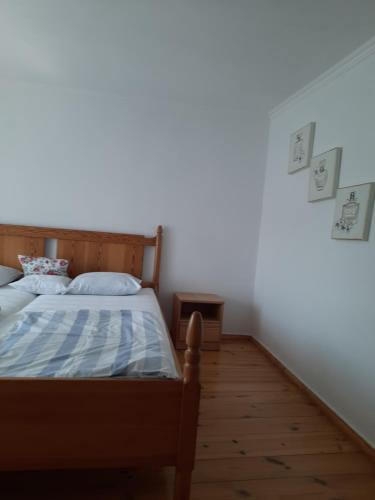 a bedroom with a bed and a white wall at Noclegi Studio Masażu in Włodawa