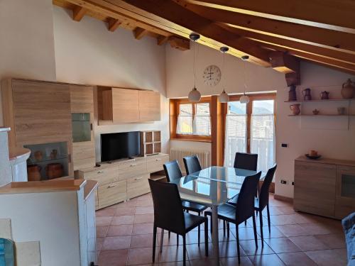 a kitchen and dining room with a table and chairs at Mansarda Belvedere in Molveno