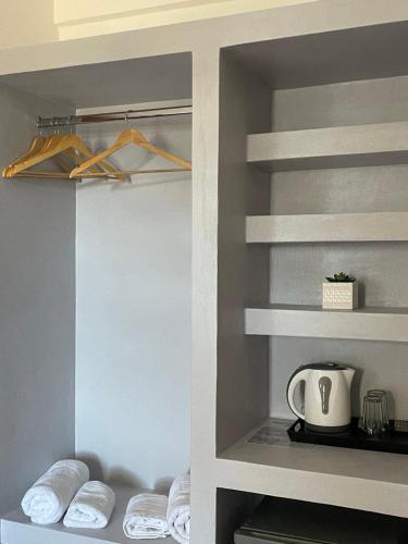 a walk in closet with white shelves and towels at Village Twins in Ios Chora