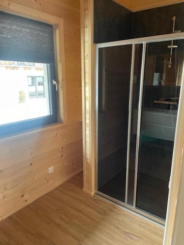 a room with a large glass window in a house at Bungalow Rattendorf - bij skigebied Nassfeld in Hermagor