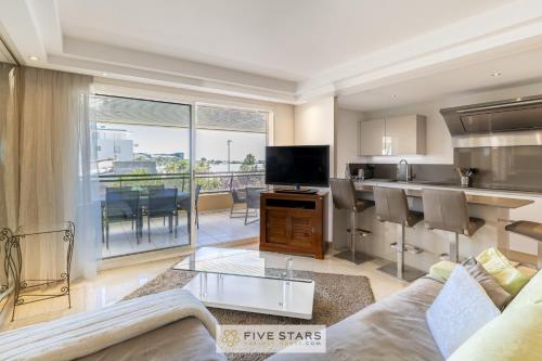 a living room with a couch and a kitchen at Suite HAITI FSHH in Saint-Laurent-du-Var