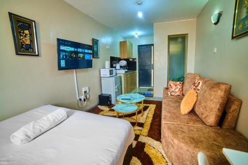 ナイロビにあるONEAL URBAN SUITES - Furnished Studio apartments in Nairobiのベッドとソファのあるリビングルーム