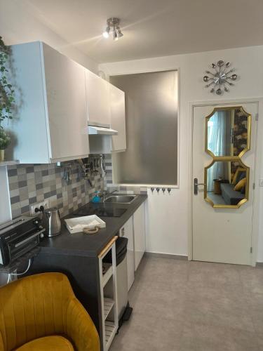 une cuisine avec des armoires blanches et un comptoir noir dans l'établissement Studio Coeur Delille FSHH, à Nice