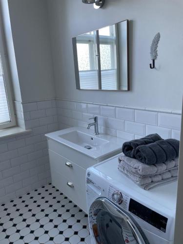 a bathroom with a washing machine and a sink at Silbernagel Villa in Kuressaare