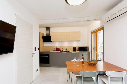 une cuisine et une salle à manger avec une table et des chaises en bois dans l'établissement Maison en centre de Cannes - Le Suquet, à Cannes