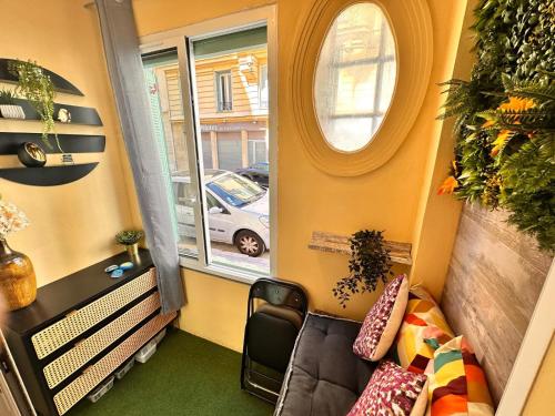 Cette petite chambre comprend un canapé et une fenêtre. dans l'établissement Studio Coeur Delille FSHH, à Nice