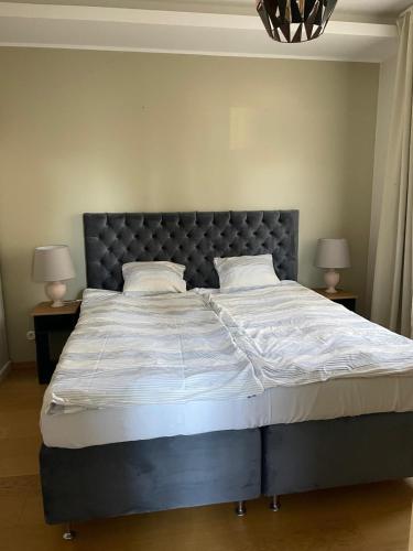 a large bed in a bedroom with two lamps at Silbernagel Villa in Kuressaare