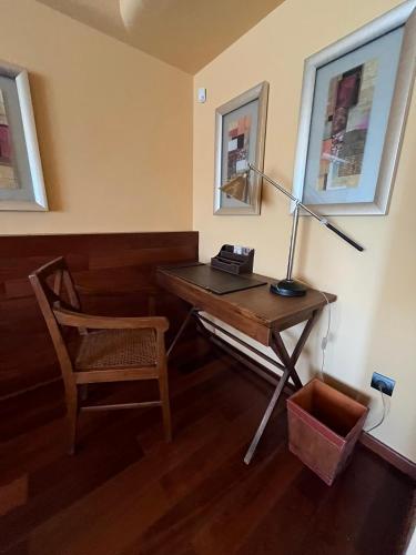 a desk with a lamp and a chair in a room at PENSIÓN EL CARRO in Utiel