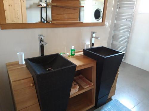 une salle de bain avec deux lavabos noirs dans une pièce dans l'établissement Maison Chalet, à Le Nayrac
