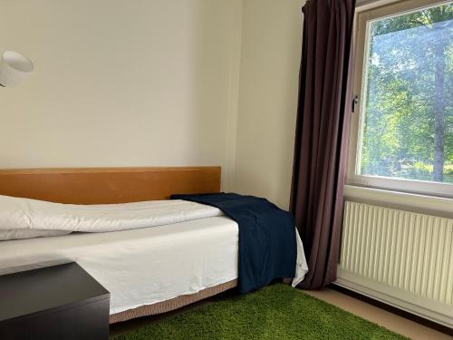 a bedroom with a bed and a window at Klackbergsgården in Norberg