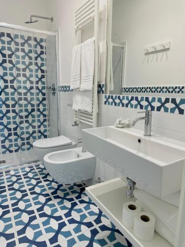 a white bathroom with a sink and a toilet at Blumare Amalfi Coast in Maiori