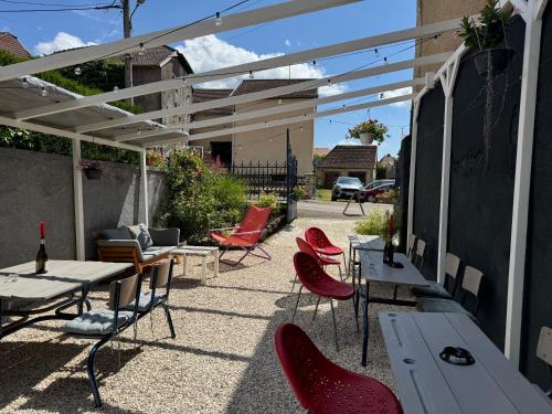 a patio with tables and chairs under a pergola at Belgica-Melay 52400 in Melay