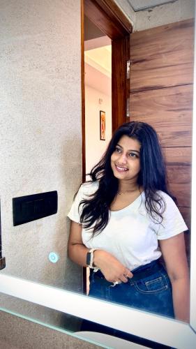 a woman is standing in front of a mirror at Raksha Suites & Banquet Greater Noida in Greater Noida