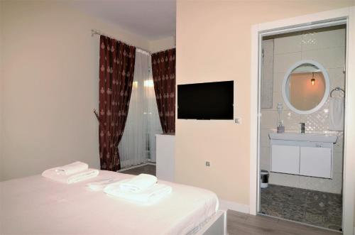 a white room with a bed and a sink and a mirror at Grand Alaçatı Butik Hotel in Alacati