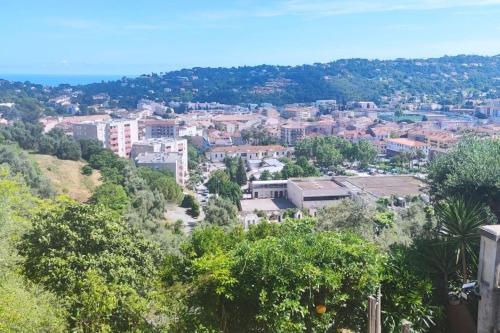une vue d'une ville avec des arbres et des bâtiments dans l'établissement Chez LINAT - Studio en rez de jardin au calme avec vue mer, à Vallauris