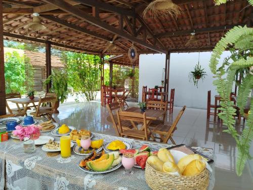 a table with plates of food on top of it at Côco Verde - Pousada Icaraí Kite Village in Icaraí