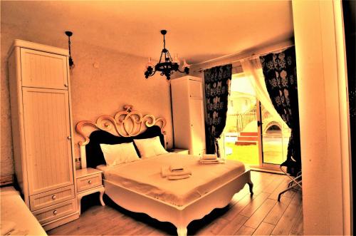 a bedroom with a large white bed with a chandelier at Grand Alaçatı Butik Hotel in Alacati