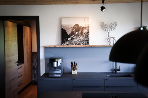 a kitchen with a counter with a coffee maker and a microwave at Platzhirsch Ofterschwang in Ofterschwang