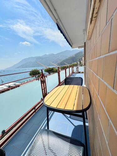 a table on a balcony with a view of the water at Blumare Amalfi Coast in Maiori