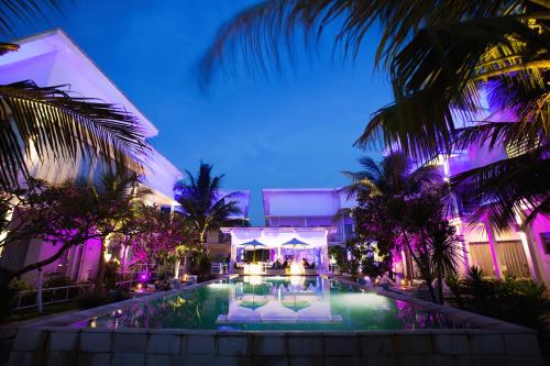 una piscina del resort con sedie e palme di notte di Ocean View Residence a Jepara