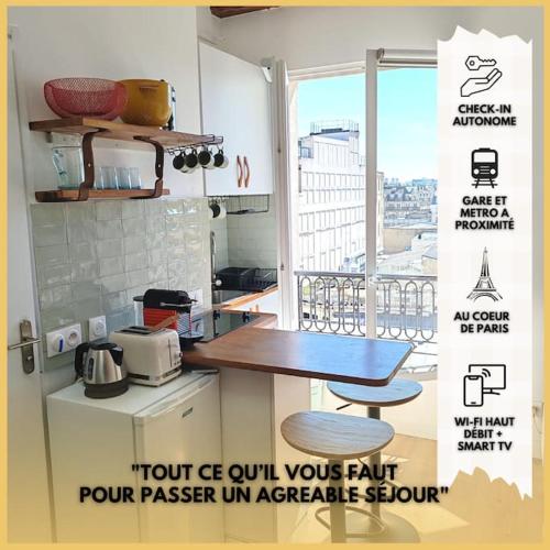 une cuisine avec un comptoir, une table et une fenêtre dans l'établissement La Cabane Parisienne - Au centre de Paris - Lumineux - Vue panoramique, à Paris