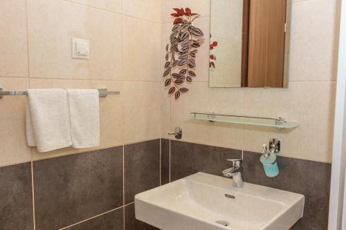a bathroom with a sink and a mirror and towels at Migazzi Vendégház in Vác