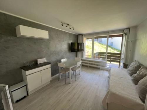 un salon avec un lit et une table et une cuisine dans l'établissement Superbe studio 4 pers skis aux pieds avec balcon, à Tignes