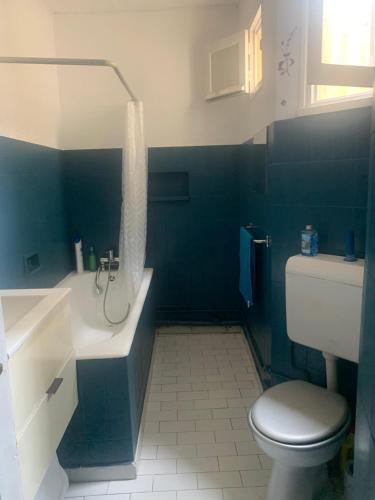 a bathroom with a toilet and a tub and a sink at Laurence in Paris