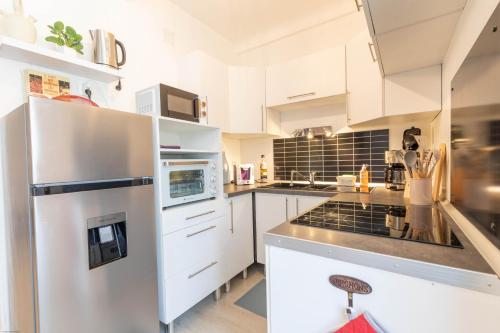 a kitchen with white cabinets and a white refrigerator at Appartement Le Welcome in Argelès-Gazost
