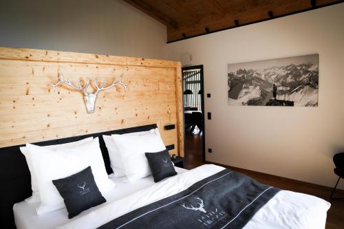 a bedroom with a bed with a wooden headboard at Platzhirsch Ofterschwang in Ofterschwang