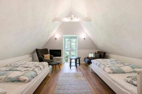 a attic bedroom with two beds and a desk at Ferienhaus Reetkate Breklum in Breklum
