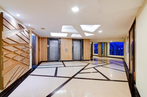 a large hallway with white tile flooring and wooden walls at HOTEL Urban Asia in kolkata