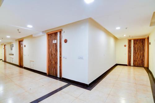 an empty room with white walls and wooden doors at HOTEL Urban Asia in kolkata