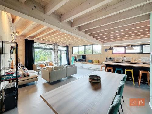 Il comprend un grand salon avec une table et une cuisine. dans l'établissement La Cabane des Bienheureux, à Wimereux