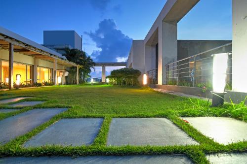 a grassy yard in front of a building at HOTEL Urban Asia in kolkata