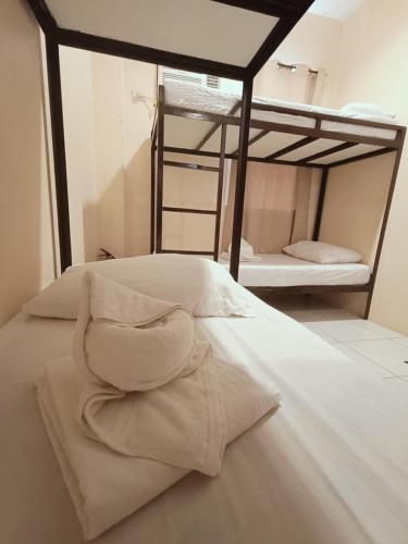 a bed with white sheets and pillows in a room at Claytown Pension House in Dumaguete