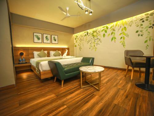 a bedroom with a bed and a table and chairs at Grand Palace Hotel & Spa in Yercaud