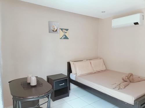 a small room with a bed and a table at Claytown Pension House in Dumaguete
