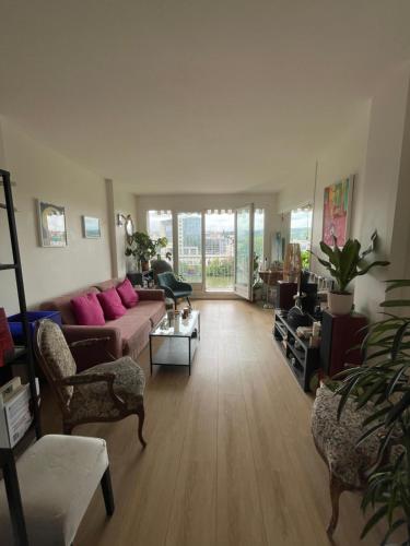 un salon avec un canapé, des chaises et une table dans l'établissement Appartement sur quai de Seine, à Boulogne-Billancourt